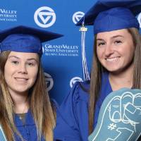 Two graduates pose with props at Gradfest